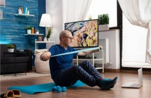 pensioner working body resistance exercising arms muscles using elastic band sitting yoga mat with c
